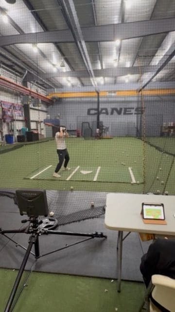 A Canes Illinois player hitting in the Naperville pitching lab with Rapsodo tracking